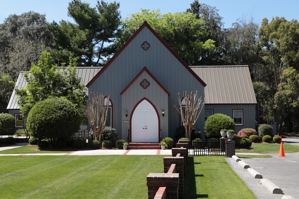 A beautiful gray steel church building with maroon trimming under the bright sun on a summer day