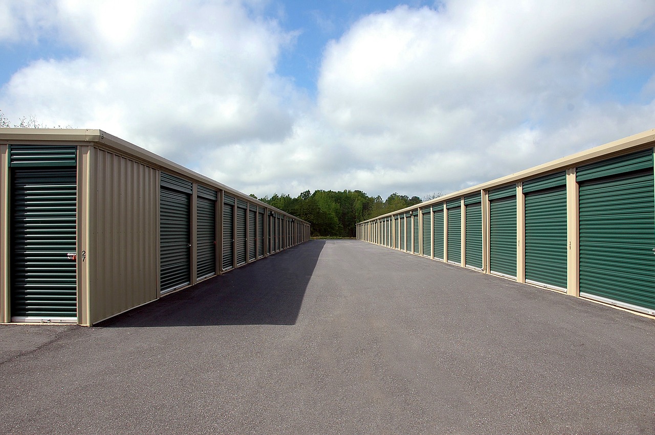 A newly erected set of tan and dark green steel storage buildings that will safely hold the belongings of residents in the area 