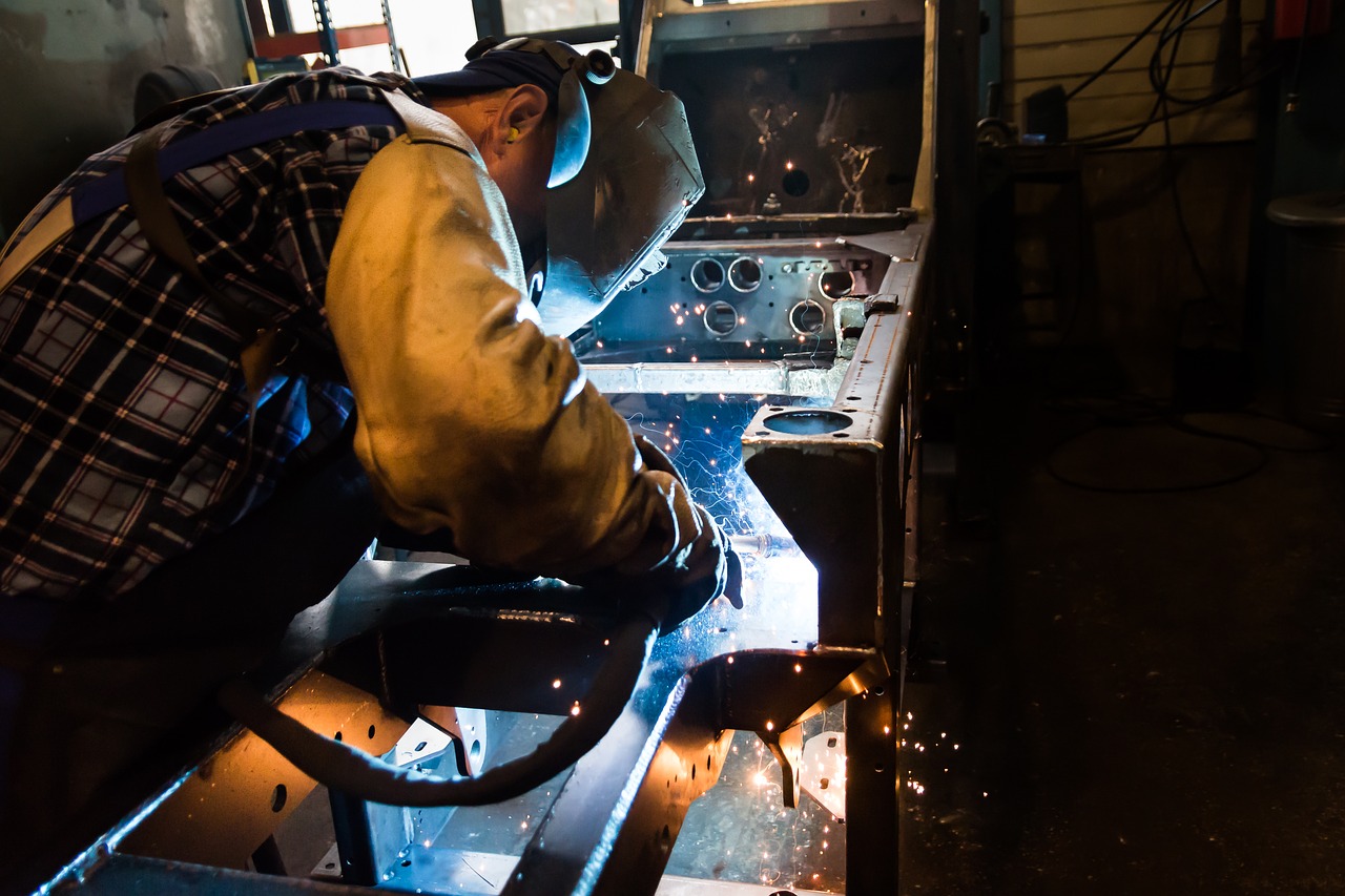 A man welding a new project in his freshly assembled steel workshop